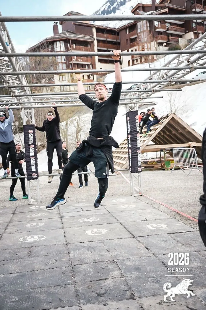 Le coach franchissant un obstacle de suspension lors d'une course à obstacles