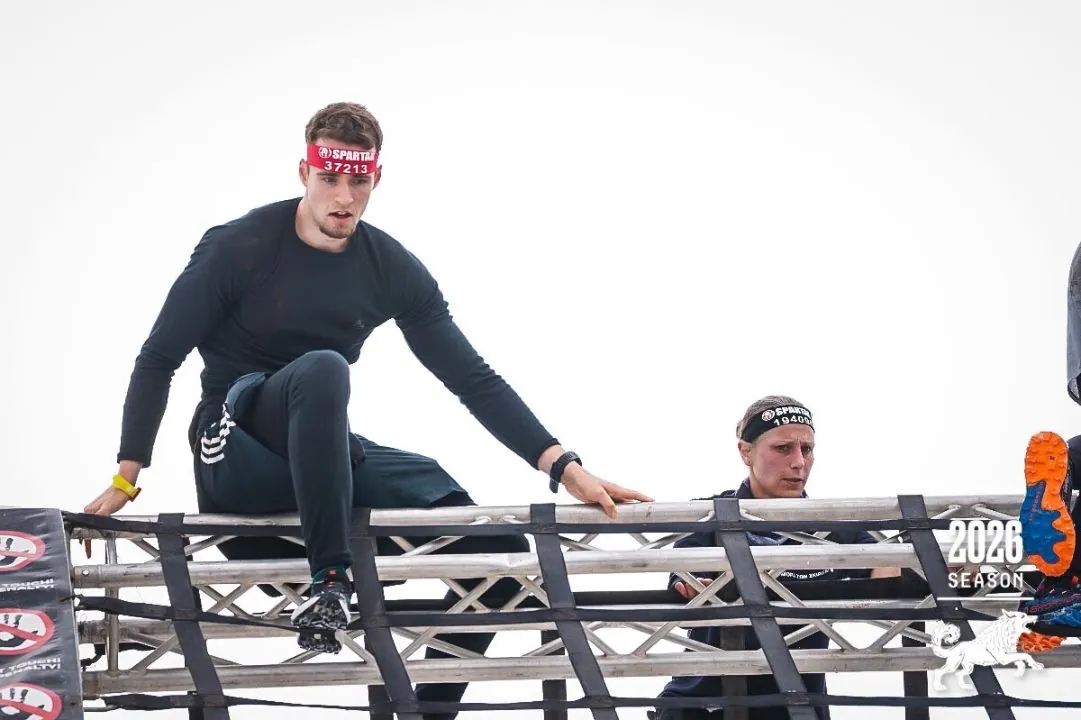 Le coach sautant par-dessus un obstacle pendant une course